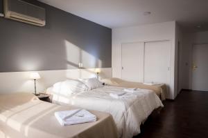 a hotel room with two beds with white sheets at Hotel 376 in Villa Carlos Paz +22 photos