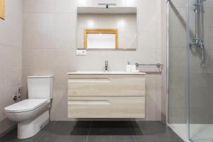 a bathroom with a toilet and a sink and a shower at APARTAMENTO LUMINOSO EN CANGAS in Cangas de Morrazo +7 photos