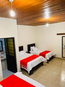 two beds in a room with red and white at HOTEL CASA D'LINA CENTRO in San Cristóbal de Las Casas