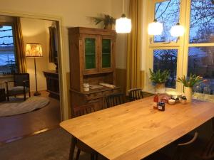 d'une salle à manger avec une table en bois et des fenêtres. dans l'établissement Warmoes tuinderswoning, à Nimègue