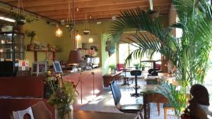 un restaurant avec des tables, des chaises et des plantes dans l'établissement Warmoes tuinderswoning, à Nimègue