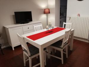 a white dining room table with a red table cloth at Davide & Mary friendly house in Novara