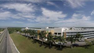 a building with palm trees in front of a highway at Holiday Inn - Villahermosa Aeropuerto, an IHG Hotel in Villahermosa