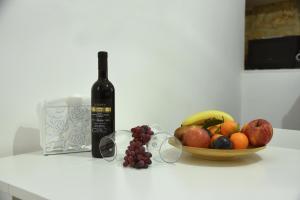 eine Flasche Wein und eine Schale Obst auf der Theke in der Unterkunft Corte32 in Bari