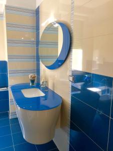 a blue bathroom with a sink and a mirror at VIOLA HOME in Salerno