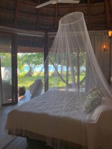 a bed with a mosquito net in a room at Pucté 13 in Bacalar