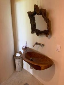 uma casa de banho com um lavatório de madeira e um espelho em Pucté 13 em Bacalar