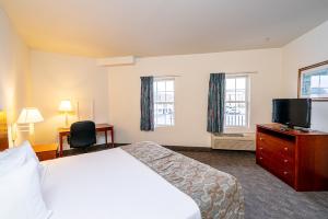 a hotel room with a bed and a flat screen tv at Anchorage Motel Inc. in Rehoboth Beach
