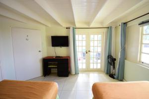 ein Wohnzimmer mit einem Sofa und einem TV in der Unterkunft The View at Mystic Ridge Penthouse 78A in Ocho Rios