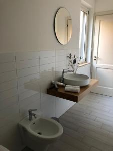 a white bathroom with a sink and a mirror at La Rinella in Caria