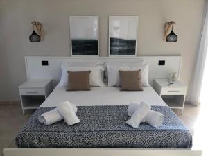 a bedroom with a large white bed with three pillows at La Rinella in Caria
