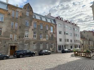 una calle con coches estacionados frente a los edificios en Old Town Charm TLN en Tallin