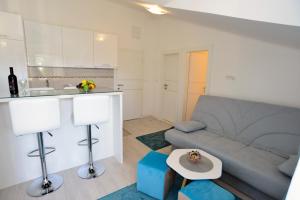 a living room with a couch and a kitchen at Apartmani Stefanija in Tivat