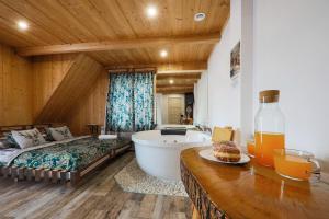 łazienka z łóżkiem i wanną w pokoju w obiekcie GÓRALSKA VILLA APARTAMENTY Z JACUZZI & HOME SPA & Zakopane w Poroninie