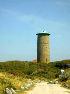 a lighthouse sitting on top of a hill at Residentie Villa de Wael in Domburg