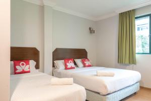two beds in a room with red and white pillows at Hotel Rose Crest Hill, Cameron Highland in Tanah Rata