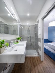 a bathroom with a sink and a shower and a bed at B&B Campari 10 in Pavia
