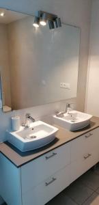 a bathroom with two sinks and a large mirror at Hispalis Gran Plaza in Seville