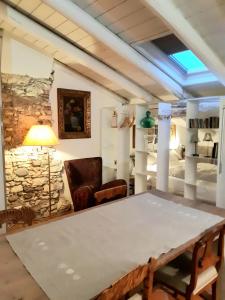 a living room with a table and a stone wall at S. Trinità 18, Suites & Rooms in Trento