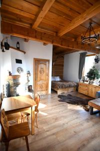 a living room with a table and a bed at Apartamenty Rogowcówka in Biały Dunajec