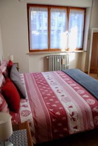 サン・ヴァンサンにあるIl Ponteのベッドルーム1室(ベッド1台、赤と白の毛布付)