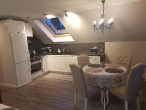 a kitchen with a table and chairs and a refrigerator at Eidsvoll Myrer in Eidsvoll