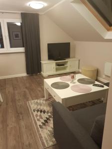 a living room with a tv and a coffee table at Eidsvoll Myrer in Eidsvoll