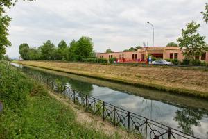 einen Fluss mit einem Zaun neben einem Gebäude in der Unterkunft B&B Campari 10 in Pavia