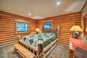 a bedroom with a bed in a room with wooden walls at Secluded Retreat with Wood Stove, 11 Mi to Bozeman! in Gallatin Gateway