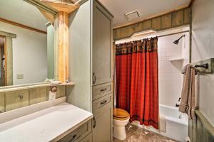 a bathroom with a toilet and a red shower curtain at Secluded Retreat with Wood Stove, 11 Mi to Bozeman! in Gallatin Gateway +28 photos