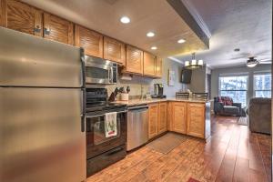 a kitchen with a stainless steel refrigerator and wooden cabinets at Copper Chase Condo Less Than 1 Mile to Brian Head Skiing! in Brian Head