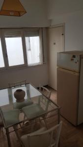 a kitchen with a glass table and a refrigerator at Departamento 2 amb centro in Mar del Plata