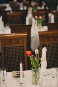 Una mesa con un jarrón de flores y velas. en Grand Hotel Hønefoss, en Hønefoss