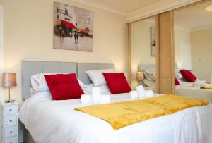 a bedroom with two large beds with red pillows at Carvetii - Derwent House - Spacious 2nd floor flat in Grangemouth