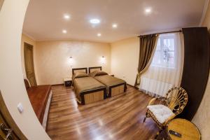 1 dormitorio con 2 camas y suelo de madera en Panorama Apart-Hotel, en Kamianets-Podilskyi