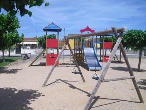 a playground with a swing set in a park at Casa Les Roques in Báscara