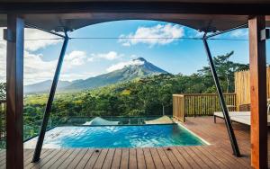 a view of a mountain from a house with a swimming pool at Nayara Tented Camp in Fortuna