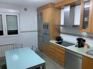 a kitchen with wooden cabinets and a white counter top at Oktheway San Eufrasio in Sarria +18 photos