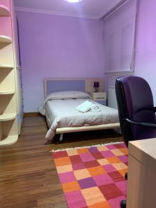 a bedroom with a bed and a chair and a rug at Oktheway San Eufrasio in Sarria