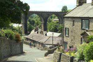 a man walking down a street with a bridge in the background at Dalecote Barn Bed & Breakfast in Ingleton 