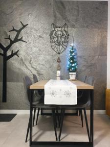 a dining room table with a christmas tree on it at Apartament Zaczarowany Las - 5D Apartamenty in Świeradów-Zdrój