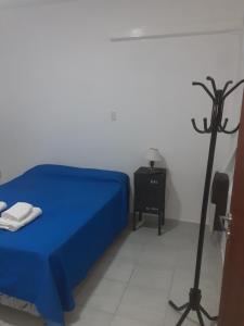 a bedroom with a blue bed and a black pole at Roberta 3 in Bahía Blanca