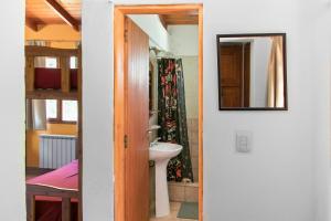 a bathroom with a sink and a mirror at Hostel El Mirador in El Bolsón +252 photos