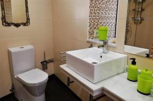 La salle de bains est pourvue d'un lavabo blanc et de toilettes. dans l'établissement Casa acogedora con vistas al mar, à Valdoviño