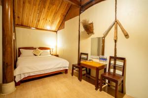 sypialnia z łóżkiem, stołem i krzesłami w obiekcie Phong Nha Coco House w mieście Phong Nha