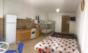 una cucina con un tavolo e una cucina con un frigorifero di EDIFICIO COSTANERA a Las Toninas