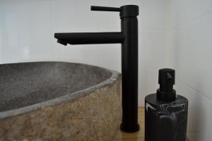 a bathroom sink with a black faucet on a counter at Te Mata Lodge in Tapu