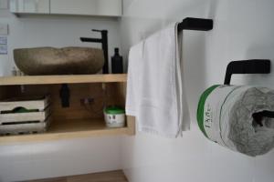 a bathroom with a roll of toilet paper on a shelf at Te Mata Lodge in Tapu