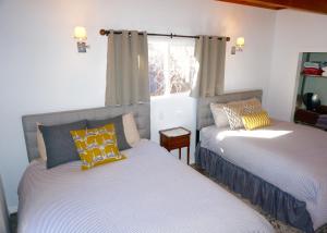 1 dormitorio con 2 camas y ventana en @SilverTipCabin en Big Bear Lake