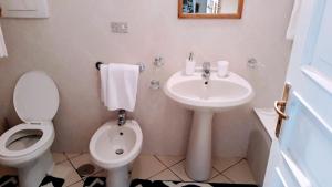 a white bathroom with a sink and a toilet at Emidio House in Termini